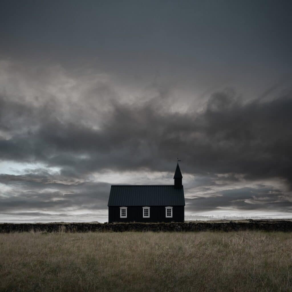 Black and white photo of a church in Iceland: A captivating black and white image showcasing a picturesque church nestled amidst the scenic landscapes of Iceland, surrounded by mountains and displaying unique architectural details.